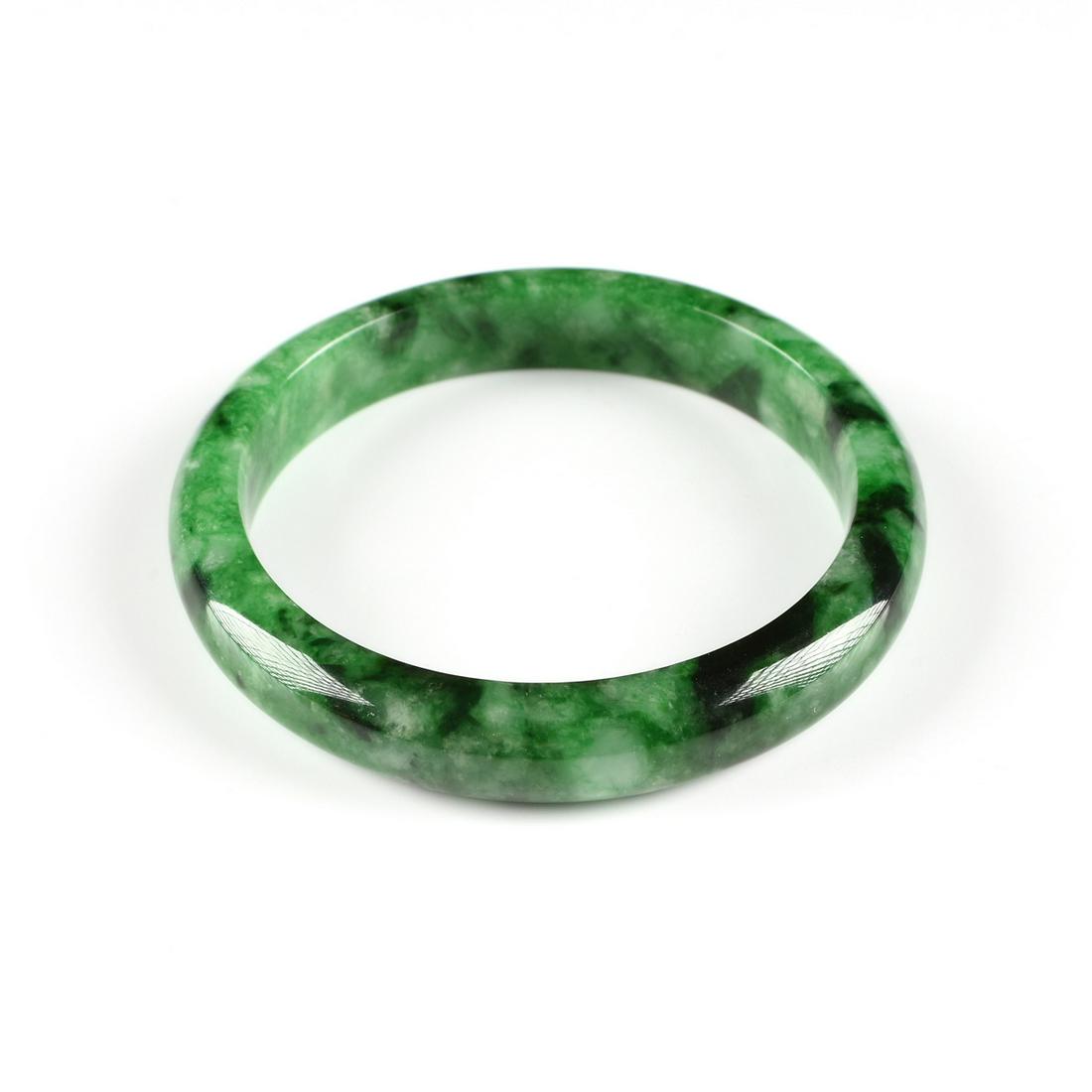 A NATURAL JADEITE BANGLE, PHU NHUAN JEWELRY, VIETNAM,: A NATURAL JADEITE BANGLE, PHU NHUAN JEWELRY, VIETNAM, LATE 20TH CENTURY, medium to dark green mottled with pale to white jade, of "D" shape, retaining retailer label, interior diameter: 2 3/8".