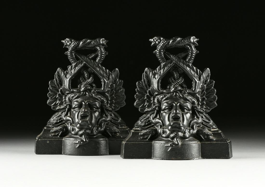 A PAIR OF VICTORIAN CAST IRON MEDUSA HEAD DOOR STOPS,: A PAIR OF VICTORIAN CAST IRON MEDUSA HEAD DOOR STOPS, SCOTTISH, FALKIRK IRON CO, MARKED, CIRCA 1875, each cast with a paired serpents entwined loop handle continuing down to the screaming winged mask 