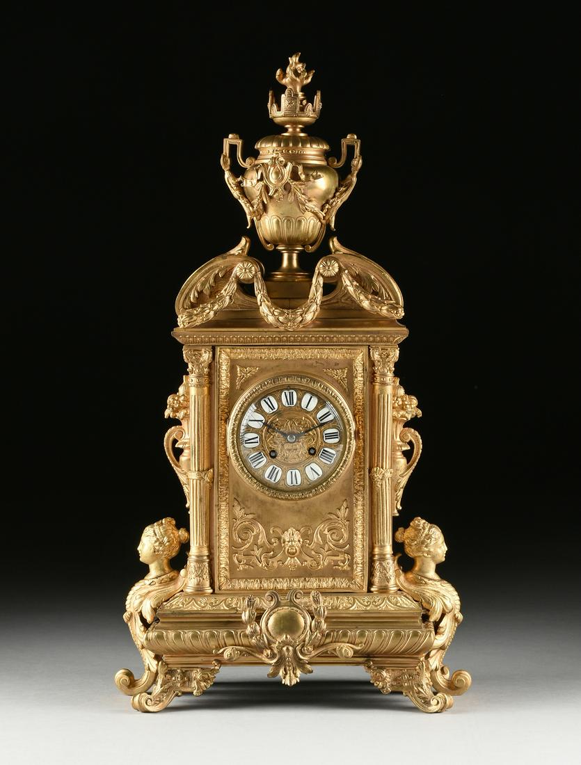 A BAROQUE REVIVAL GILT BRONZE MANTLE CLOCK, FRENCH,: A BAROQUE REVIVAL GILT BRONZE MANTLE CLOCK, FRENCH, SECOND HALF 19TH CENTURY, the bombé two handle lidded and flaming urn on a short block form plinth, centered by an architectural scrolling brok