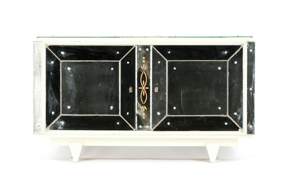 A FRENCH ART MODERNE MIRRORED AND WHITE PAINTED: A FRENCH ART MODERNE MIRRORED AND WHITE PAINTED CREDENZA,1950s, in a Hollywood Regency style with a rectangular top of two large mirrored panels centering a reverse cut and gilt stylized flower panel,