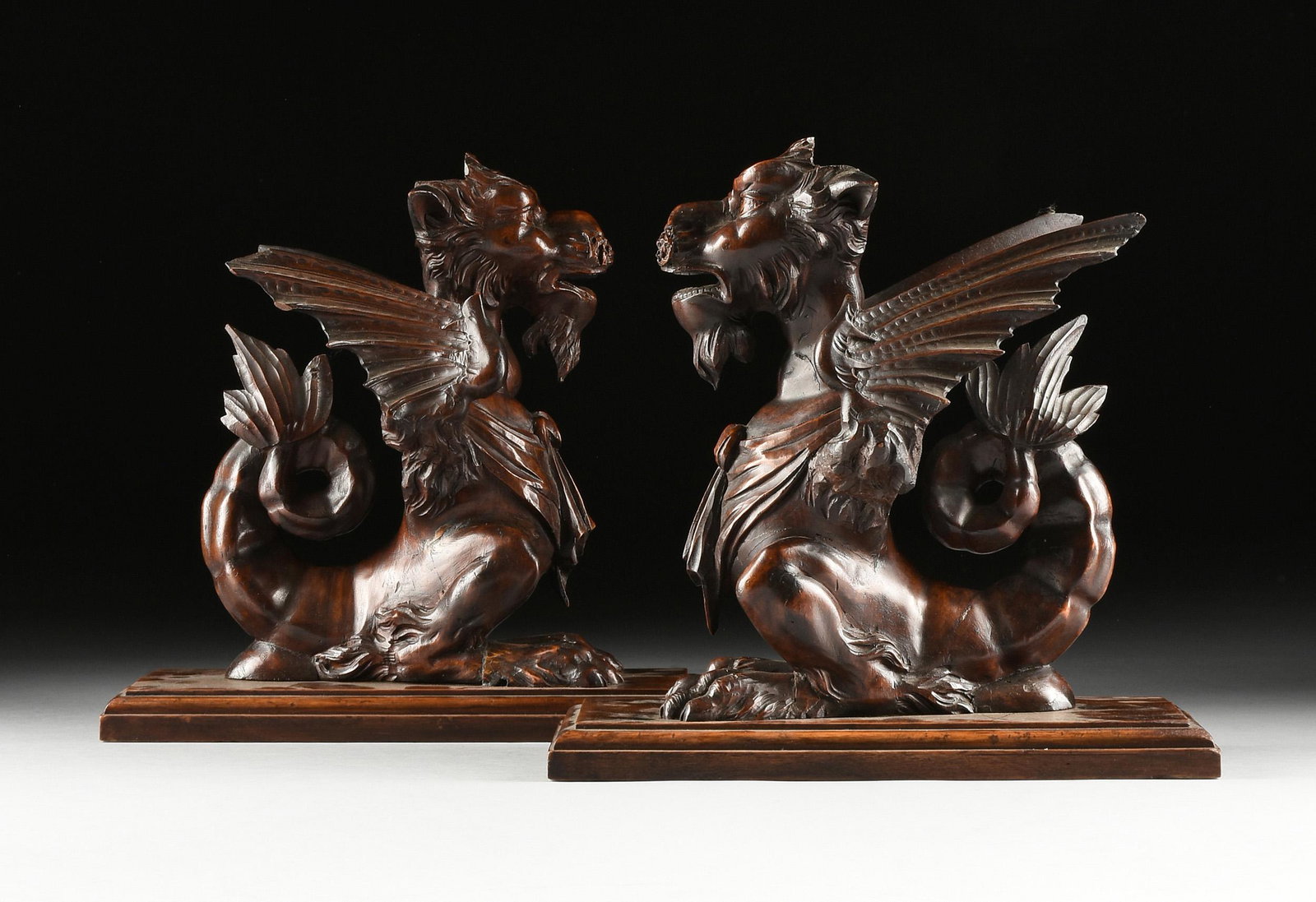 A PAIR OF ITALIAN RENAISSANCE REVIVAL WALNUT DRAGONS,: A PAIR OF ITALIAN RENAISSANCE REVIVAL WALNUT DRAGONS, LATE 19TH/EARLY 20TH CENTURY, sculptural support remnants from a large buffet or sideboard, each with fierce growling expressions and winged bodie