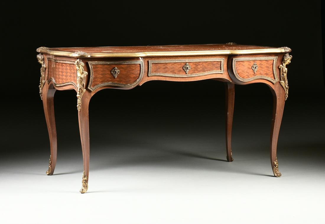 A LOUIS XV STYLE ORMOLU MOUNTED TULIPWOOD PARQUETRY: A LOUIS XV STYLE ORMOLU MOUNTED TULIPWOOD PARQUETRY BUREAU PLAT, LATE 19TH/EARLY 20TH CENTURY, the serpentine rectangular top centering an inset gilt tooled brown leather writing surface within a fram