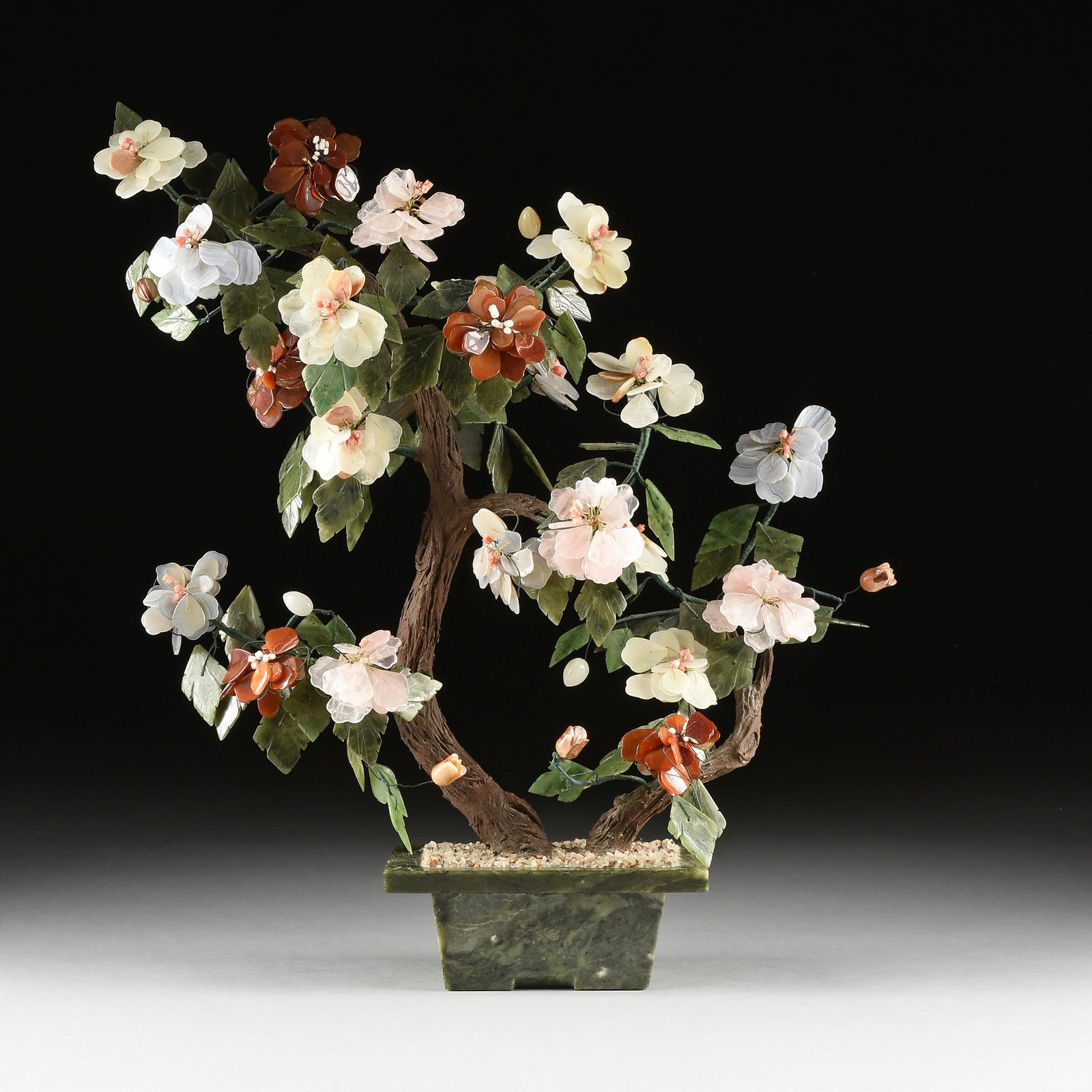 A CHINESE CARVED JADE AND HARDSTONES BLOSSOMING TREE,: A CHINESE CARVED JADE AND HARDSTONES BLOSSOMING TREE, MODERN, with each flower bloom composed of petals carved from a particular color of transparent striped agates, including red, lavender, pale lemo