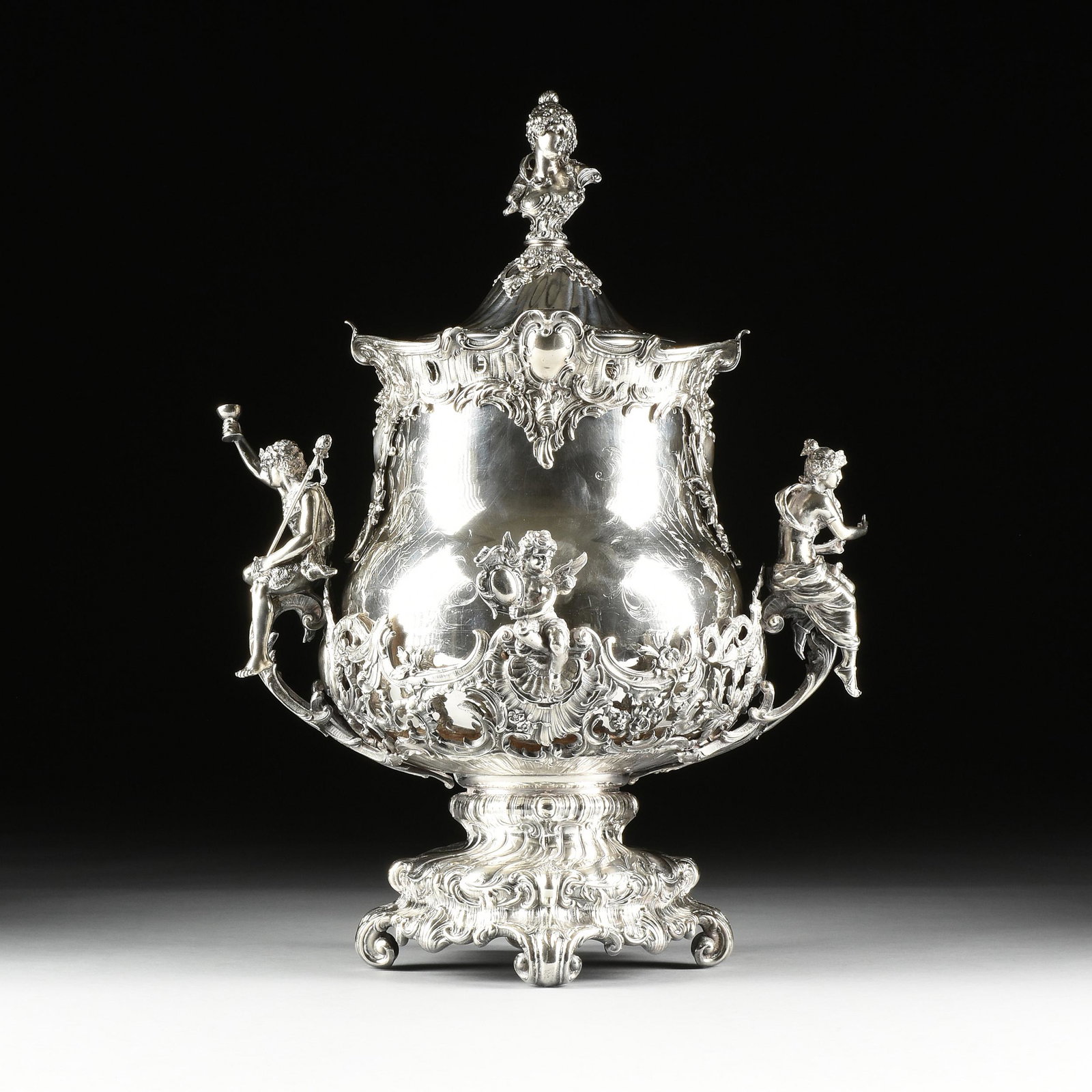 A ROCOCO REVIVAL STYLE SILVERPLATED AND LIDDED PUNCH: A ROCOCO REVIVAL STYLE SILVERPLATED AND LIDDED PUNCH URN, 20TH CENTURY, of bombé vasiform with a circular twist gadrooned lid surmounted by a bacchanalian maiden's bust finial, above a detachable rim