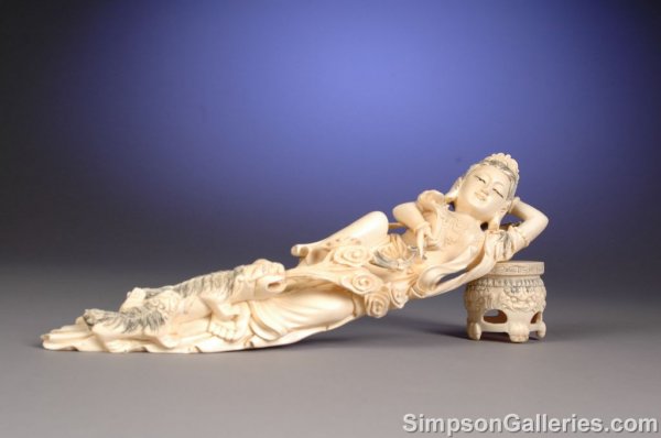 A CHINESE CARVED IVORY FIGURE OF QUANYIN modeled