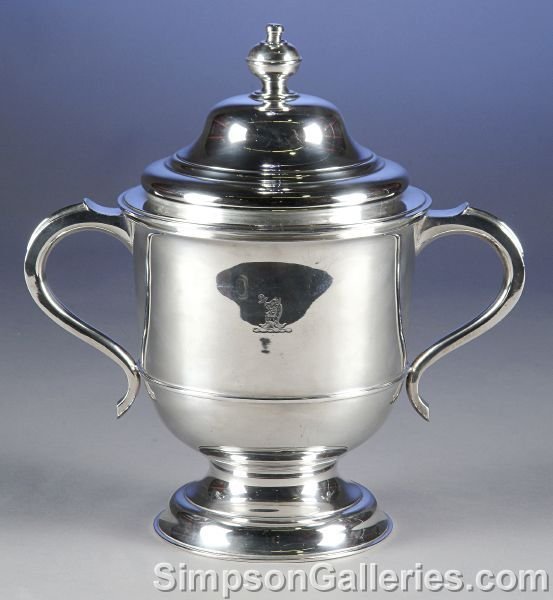 AN ARMORIAL QUEEN ANNE STYLE STERLING SILVER TWO-H: AN ARMORIAL QUEEN ANNE STYLE STERLING SILVER TWO-HANDLE PRESENTATION CUP AND COVER, by Lionel Alfred Creichton, London, 1928, the circular step domed lid with flattened bun finial on circular tapering