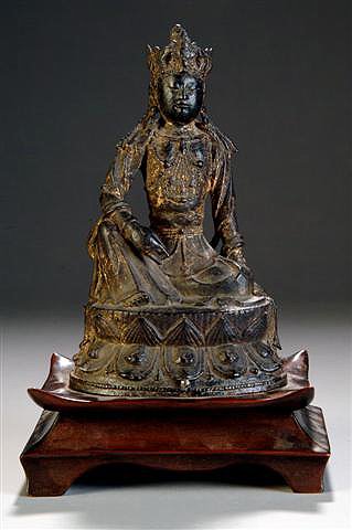 A ANTIQUE CHINESE GOLD LACQUERED BRONZE FIGURE OF Q: A ANTIQUE CHINESE GOLD LACQUERED BRONZE FIGURE OF QUAN YIN, circa 16th/17th century, shown wearing a lotus crown, seated on a lotus throne, right hand held in Buddhist Mudra. On wood stand. Height: 9 