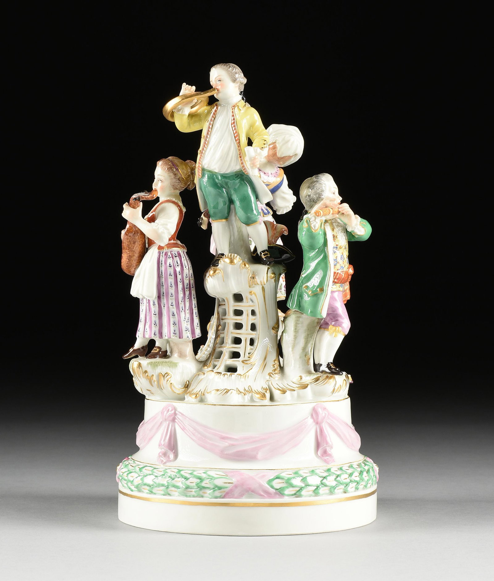 A MEISSEN PORCELAIN FIGURAL GROUP, "REVELRY," AFTER A: A MEISSEN PORCELAIN FIGURAL GROUP, "REVELRY," AFTER A MODEL BY JOHANN JOACHIM KÄNDLER, LAST HALF 20TH CENTURY, parcel gilt enameled glazed porcelain figures of musicians playing flute, hurdy-gurdy, F