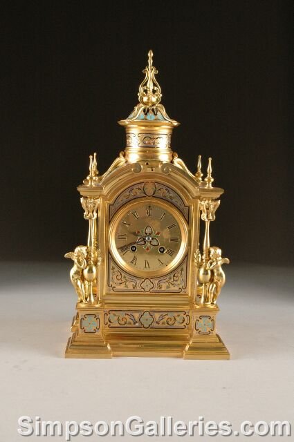 A NAPOLEON III CHAMPLEVÉ ENAMELED GILT BRONZE MANT: A NAPOLEON III CHAMPLEVÉ ENAMELED GILT BRONZE MANTLE CLOCK, third quarter 19th century, the arched rectangular case decorated with stylized foliage centering a circular dial enclosing Roman chapters
