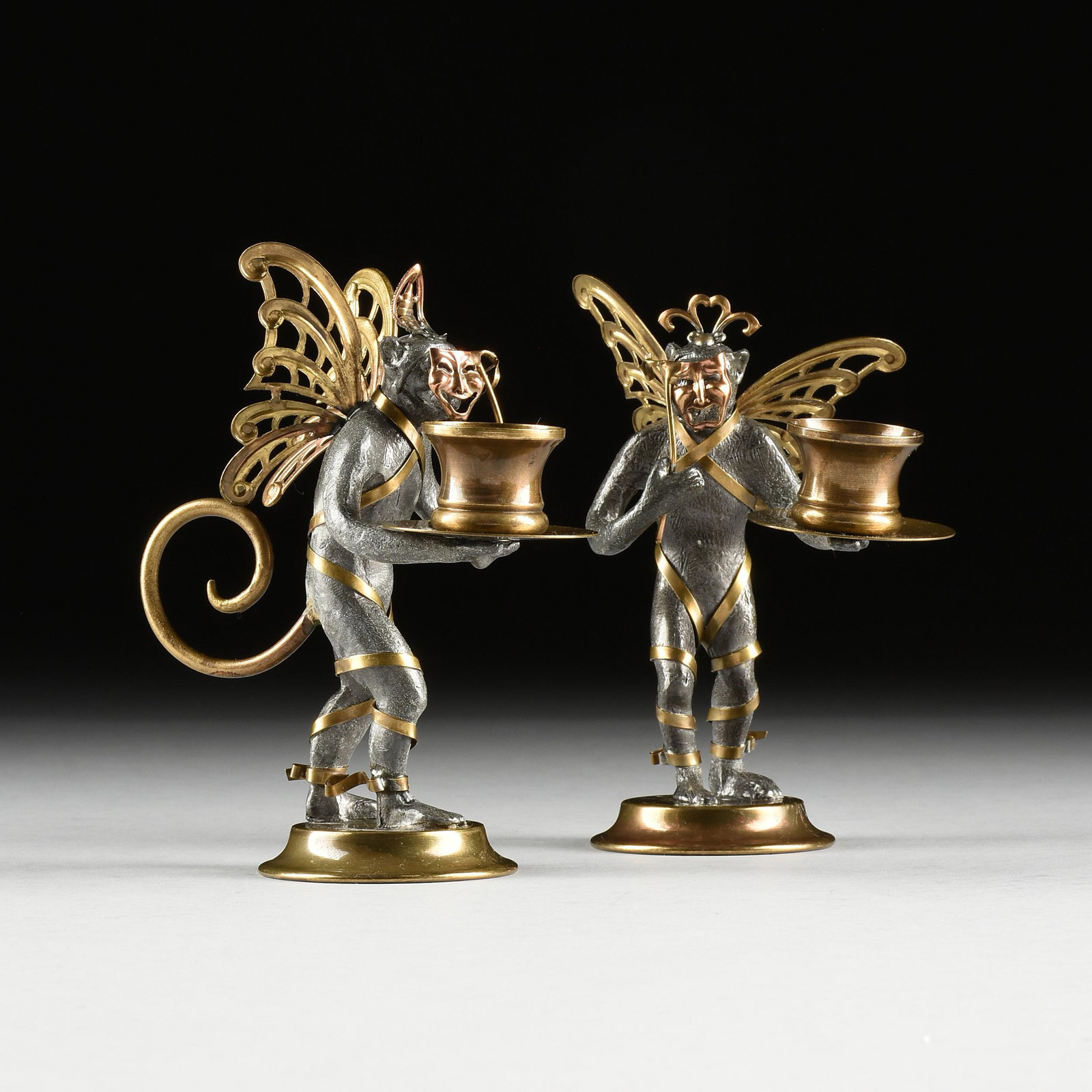 A PAIR OF MARDI GRAS/CARNIVAL THEATRICAL BRASS AND LEAD: A PAIR OF MARDI GRAS/CARNIVAL THEATRICAL BRASS AND LEAD MONKEY CANDLE STANDS, MODERN, each realistically cast in standing position and wearing a pierced triple "C" diadem over a single brass ribbon wr
