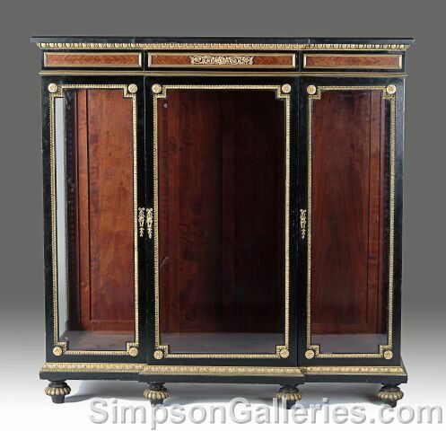A NAPOLEON III GILT BRONZE MOUNTED EBONY AND AMARA: A NAPOLEON III GILT BRONZE MOUNTED EBONY AND AMARANTH VITRINE, circa 1870, the shaped rectangular black marble top above a three panel frieze beneath an egg and dart border centering a foliate panel o