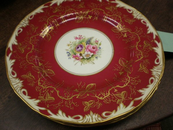 A SERVICE OF TWELVE ROYAL WORCESTER SERVICE PLATES : A SERVICE OF TWELVE ROYAL WORCESTER SERVICE PLATES in the Elegant pattern, each centering a bouquet of delicate flowers within a magenta ground enriched with foliate gilding and an acanthus border. Di