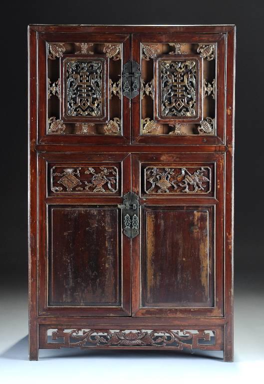 AN ANTIQUE CHINESE PARCEL GILT PAINTED CARVED WOOD: AN ANTIQUE CHINESE PARCEL GILT PAINTED CARVED WOOD CABINET, the rectangular top on paired short doors enclosing conforming panels of single character marks within carved bats and dragons over two long