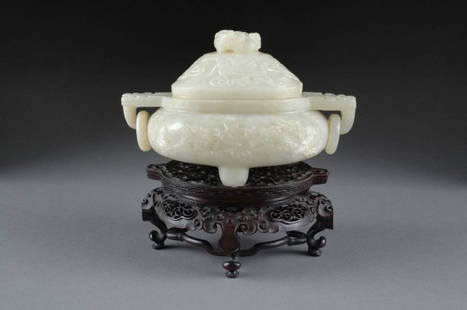 AN ANTIQUE CHINESE CARVED JADE TRIPOD CENSER AND C: AN ANTIQUE CHINESE CARVED JADE TRIPOD CENSER AND COVER, 19TH CENTURY, of traditional form with sides carved with dragons amongst scrolling clouds centered by taotie masks suspending loop handles and s