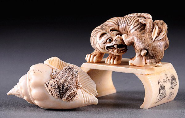 AN EDO PERIOD CARVED IVORY NETSUKE STUDY of a tiger: AN EDO PERIOD CARVED IVORY NETSUKE STUDY of a tiger attacking a rabbit, signature and himitoshi on foot, raised on a bone carved stand, including an Edo period netsuke of a shell with frog, himitoshi 
