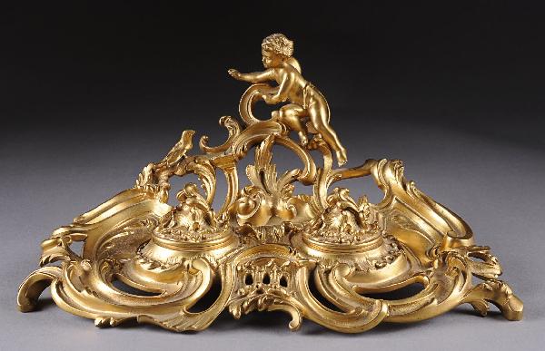 A LOUIS XV STYLE GILT BRONZE ENCRIER BY TIFFANY ST: A LOUIS XV STYLE GILT BRONZE ENCRIER BY TIFFANY STUDIOS, LATE 19TH/EARLY 20TH CENTURY, elegantly cast with a scantly clad frolicking putto and dove seated amongst reticulated "C" scrolls and stylized 