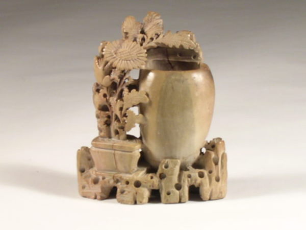 A Chinese carved steatite vase modeled with flowerin