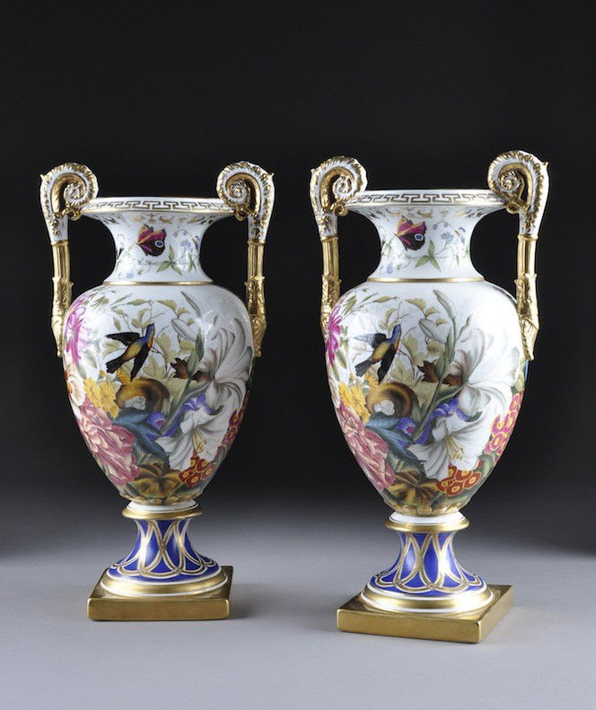 A PAIR OF NEOCLASSICAL STYLE PARCEL GILT TWO HANDLE: A PAIR OF NEOCLASSICAL STYLE PARCEL GILT TWO HANDLED VASES, MODERN, each of amphora form with enameled nesting birds amidst lush flora and fauna beneath a waisted neck centering fluttering butterflies