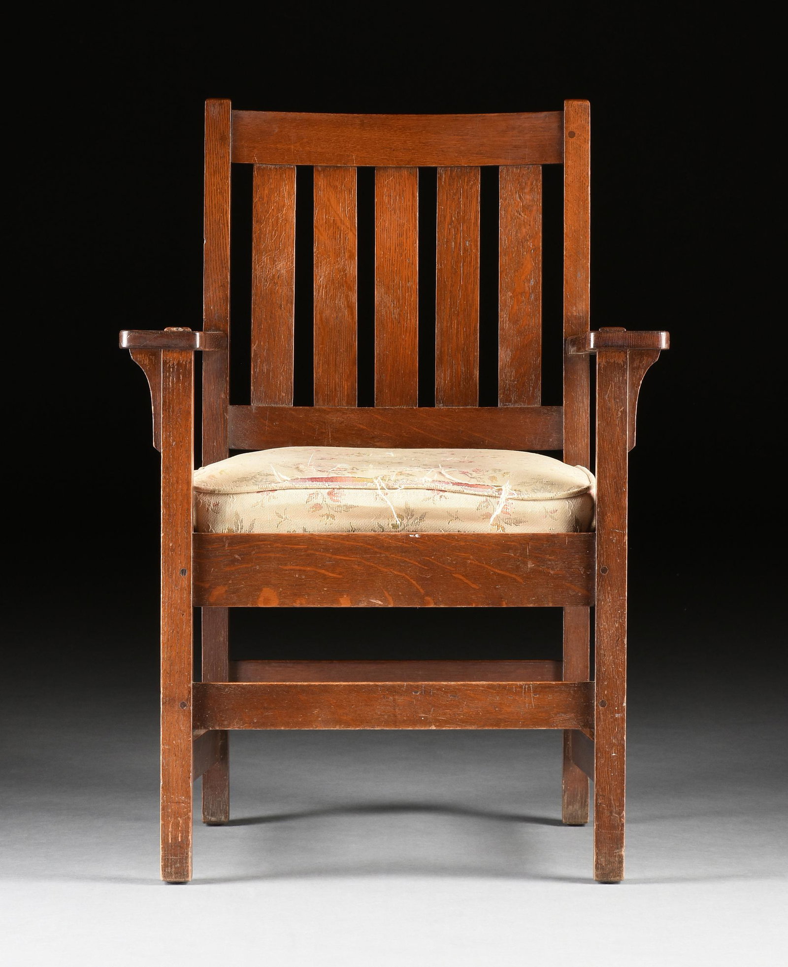 A STICKLEY BROTHERS CO. ARTS AND CRAFTS OAK ARMCHAIR, BRANDED MARK, LABELED, GRAND RAPIDS, MICHIGAN,: A STICKLEY BROTHERS CO. ARTS AND CRAFTS OAK ARMCHAIR, BRANDED MARK, LABELED, GRAND RAPIDS, MICHIGAN, 1851-1954, the slightly contoured horizontal plank crestrail above a five slat panels back flanked 
