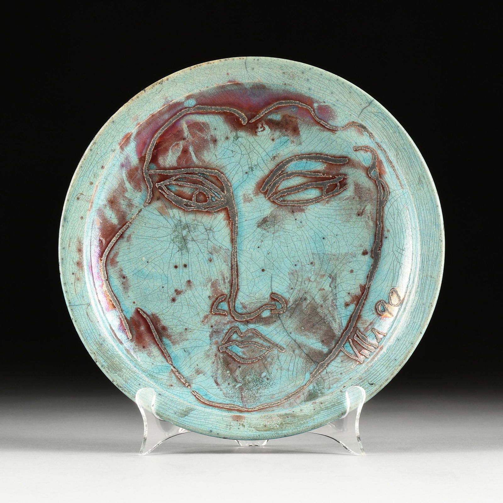 MARIO VILLA (Nicaraguan/New Orleans 1953-2021) A PLATE, "Head of Man," 1990,: MARIO VILLA (Nicaraguan/New Orleans 1953-2021) A PLATE, "Head of Man," 1990, turquoise and aubergine glazed, hand thrown and carved earthenware, signed and dated L/R, "Villa '90." Diameter: 11 1/