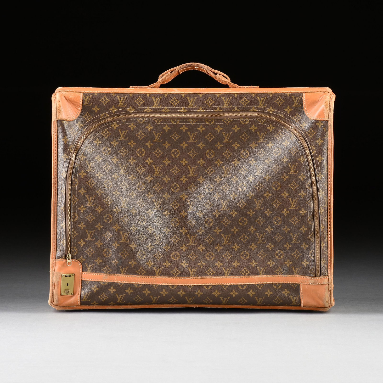 A VINTAGE LOUIS VUITTON SOFTSIDED SUITCASE, AMERICAN, 1970s,: A VINTAGE LOUIS VUITTON SOFTSIDED SUITCASE, AMERICAN, 1970s, side zipper with classic monogram logo exterior, trimmed in leather and brass feet with studs, interior with paper label, with travel appli