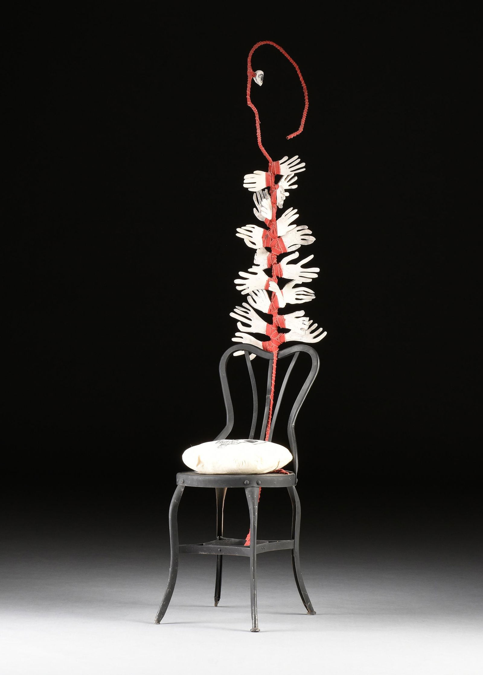ELENA CUSI WORTHAM (Mexican/Texas 1935-2020) MIXED MEDIA SCULPTURE, "Hand-Y-Chair," 1993,: ELENA CUSI WORTHAM (Mexican/Texas 1935-2020) MIXED MEDIA SCULPTURE, "Hand-Y-Chair," 1993, a black painted wood/steel chair, black felt tip drawn skull on cloth pillow, ceramic hands/eye, and red cloth