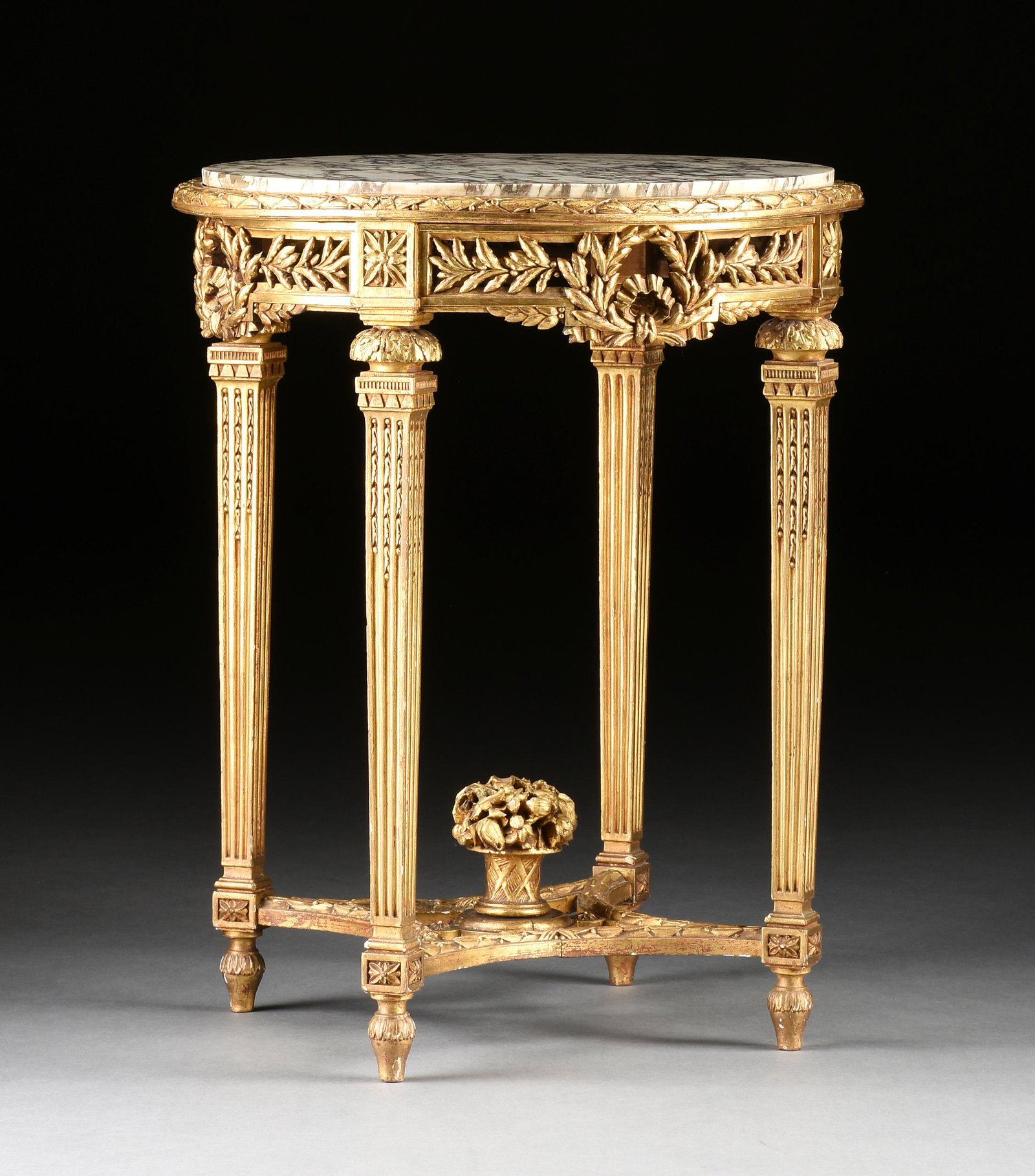 A LOUIS XVI STYLE MARBLE TOPPED AND GILT CARVED WOOD CIRCULAR SIDE TABLE, LATE 19TH/EARLY 20TH: A LOUIS XVI STYLE MARBLE TOPPED AND GILT CARVED WOOD CIRCULAR SIDE TABLE, LATE 19TH/EARLY 20TH CENTURY, the Breche Violette marble top within a berried leafy band, over a pierced paneled frieze of bow