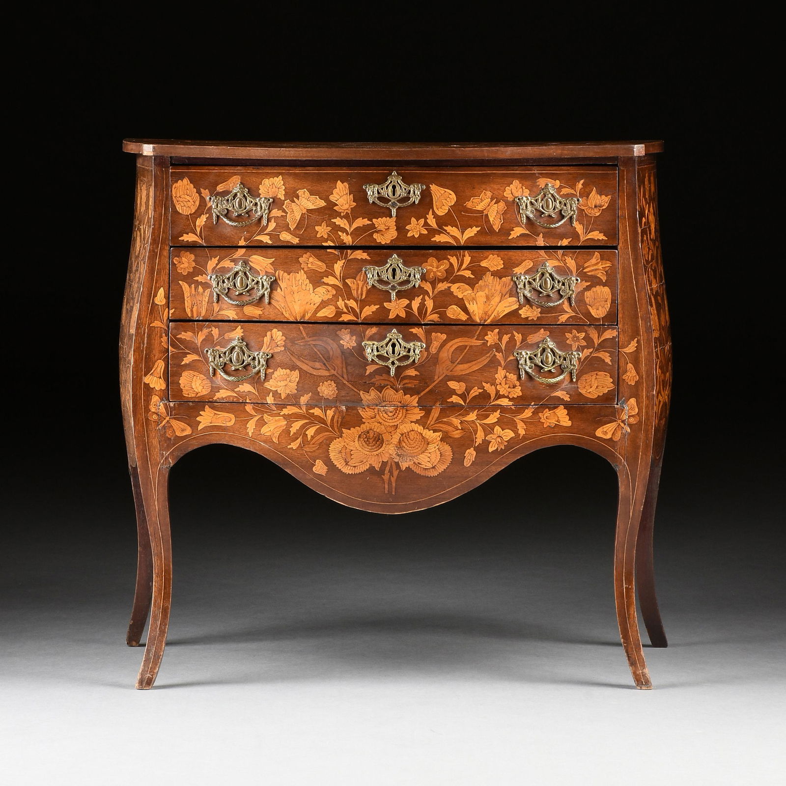 A DUTCH FRUITWOOD BUTTERFLIES AND FLORAL MARQUETRY INLAID WALNUT PETITE COMMODE, 19TH CENTURY,: A DUTCH FRUITWOOD BUTTERFLIES AND FLORAL MARQUETRY INLAID WALNUT PETITE COMMODE, 19TH CENTURY, in the Rococo style with a serpentine rectangular top centering a large floral cluster issuing long bloss