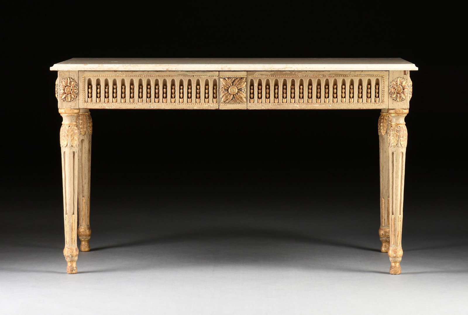 AN ITALIAN NEOCLASSICAL MARBLE TOPPED PARCEL GILT AND WHITE PAINTED WOOD CONSOLE TABLE, 19TH/20TH: AN ITALIAN NEOCLASSICAL MARBLE TOPPED PARCEL GILT AND WHITE PAINTED WOOD CONSOLE TABLE, 19TH/20TH CENTURY, the later rectangular cream white marble top above a fleur d'asperges stop fluted frieze encl