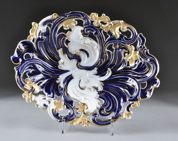 A MEISSEN PARCEL GILT AND DEEP BLUE ENAMELED RETI: A MEISSEN PARCEL GILT AND DEEP BLUE ENAMELED RETICULATED DISPLAY BOWL, BLUE CROSSED SWORDS MARKS, PRESSNUMMERS 54, 142, 232, 20TH CENTURY, of shallow oval form with pierced scrolling acanthus leaves a