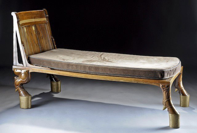 A FRENCH EGYPTIAN STYLE IVORY-INLAID AND WALNUT CH: A FRENCH EGYPTIAN STYLE IVORY-INLAID AND WALNUT CHAISE LOUNGE, CIRCA 1880 The design modeled after the Egyptian 18th Dynasty, with a rectangular concave and planked back, the crest with a horn hourgla