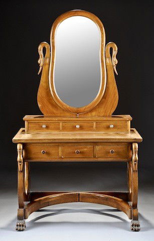 A CONTINENTAL BIEDERMEIER CARVED FRUITWOOD DRESSIN: A CONTINENTAL BIEDERMEIER CARVED FRUITWOOD DRESSING TABLE, CIRCA 1825, the tapered rectangular top with three short drawers surmounted by a paired swan's detailed swivel stand enclosing a conforming b
