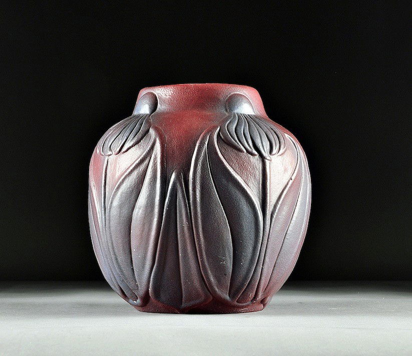 A VAN BRIGGLE MULBERRY VASE, CORN FLOWER, SIGNED,: A VAN BRIGGLE MULBERRY VASE, CORN FLOWER, SIGNED, EARLY 20TH CENTURY, of circular tapering form centering a band of molded stylized cornflowers in relief, on a mauve ground with lavender washed highli