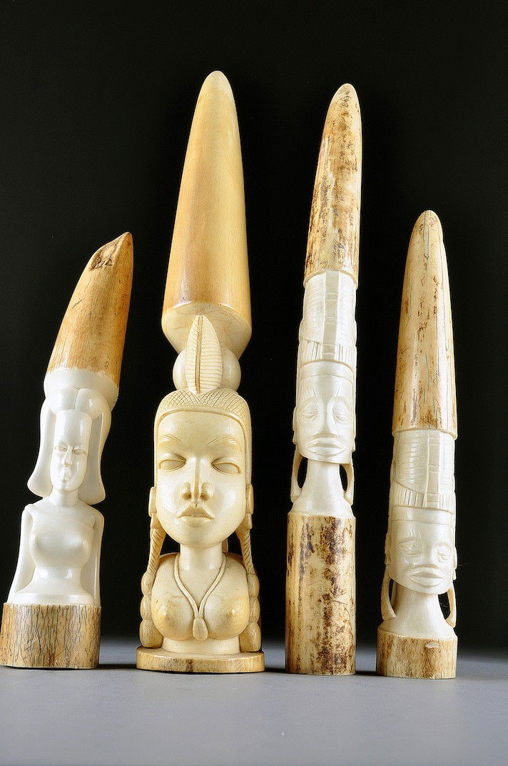 128 A GROUP OF FOUR AFRICAN IVORY CARVINGS OF NATIVE M