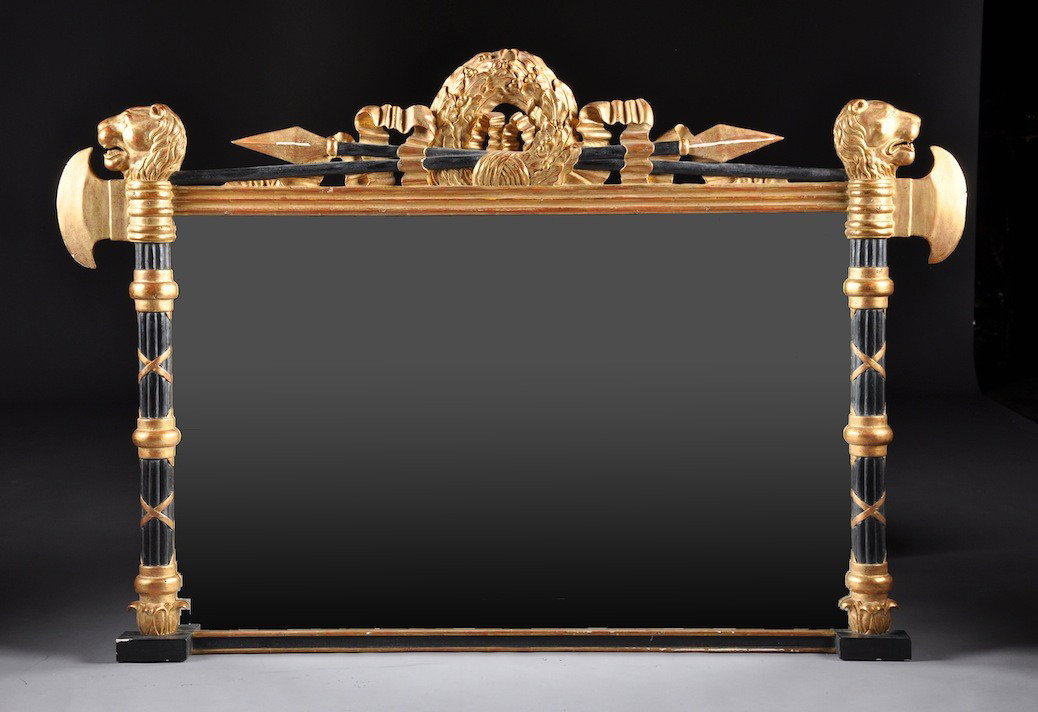 A NEOCLASSICAL STYLE PARCEL GILT AND EBONIZED CARV: A NEOCLASSICAL STYLE PARCEL GILT AND EBONIZED CARVED WOOD MANTLE MIRROR, POSSIBLY ITALIAN, 20TH CENTURY, the rectangular mirrored plate surmounted by a reticulated crest rail centering a ribbon-tied b