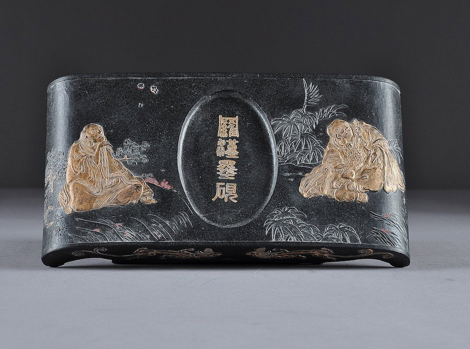 A VINTAGE CHINESE PARCEL GILT CARVED AND MOLDED IN: A VINTAGE CHINESE PARCEL GILT CARVED AND MOLDED INK CAKE STAND, FIRST HALF 20TH CENTURY, delicately scented and of rounded rectangular form centering an oval recessed well with four character impresse