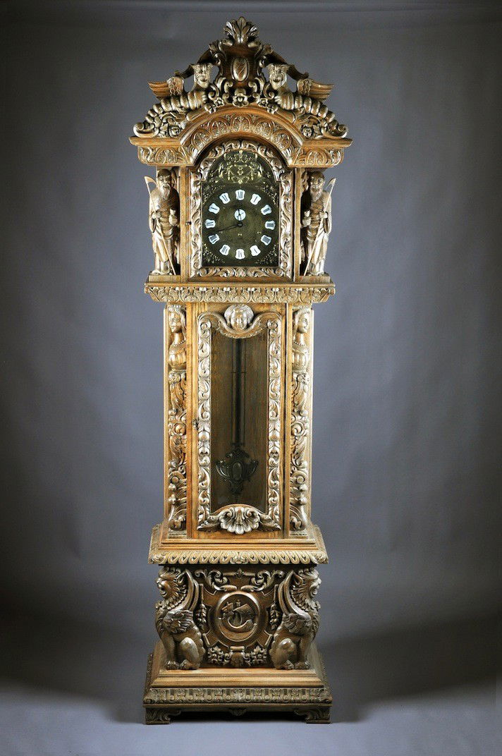 A BAROQUE STYLE CARVED OAK TALL CASE CLOCK, BY GAZ: A BAROQUE STYLE CARVED OAK TALL CASE CLOCK, BY GAZO, 20TH CENTURY, the arched bonnet centering a cabochon armorial cartouche flanked by snarling winged chimaera above a conforming glazed door within t