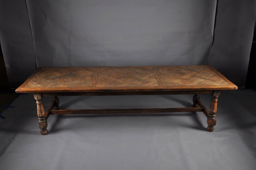 A LOUIS XIII CARVED WALNUT CENTER TABLE, 17TH CENT: A LOUIS XIII CARVED WALNUT CENTER TABLE, 17TH CENTURY, the later 18th Century oak parquet de Versailles rectangular top above a plain frieze on short Doric columnar legs raised on turned block and bun