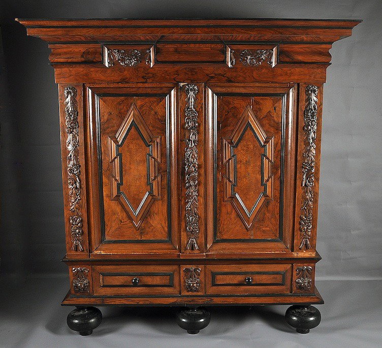 A DUTCH BAROQUE STYLE ROSEWOOD, WALNUT AND EBONIZE: A DUTCH BAROQUE STYLE ROSEWOOD, WALNUT AND EBONIZED WOOD KAS, 19TH CENTURY, the molded rectangular top above a frieze centering berried blossoming stem carved panels over paired doors enclosing raised