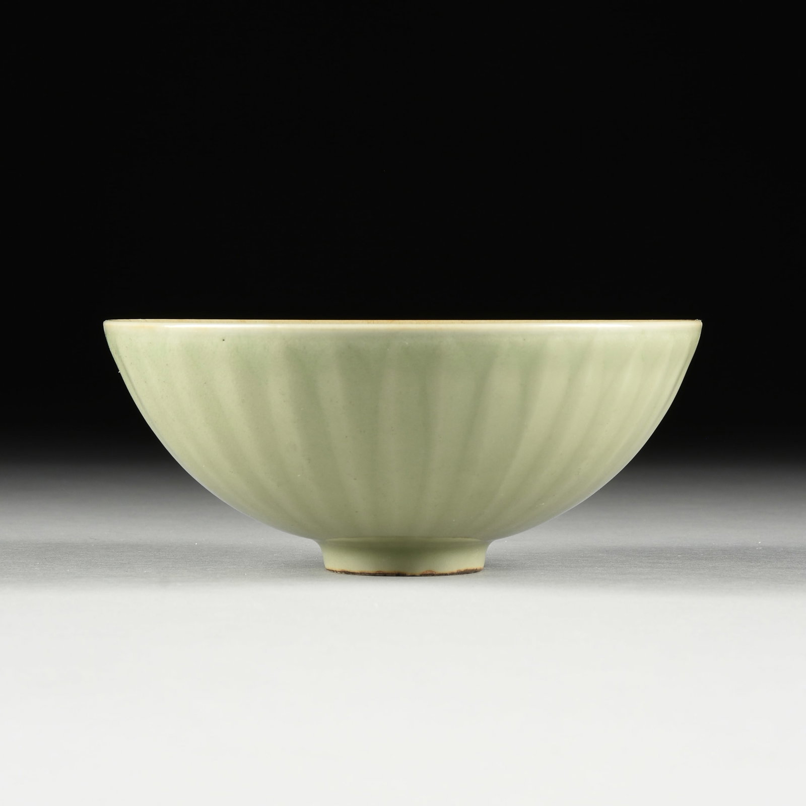 A CHINESE MING DYNASTY STYLE CELADON GLAZE "CHRYSANTHEMUM" BOWL, 20TH CENTURY,: A CHINESE MING DYNASTY STYLE CELADON GLAZE "CHRYSANTHEMUM" BOWL, 20TH CENTURY, the bowl of domed form with a smooth interior dish and a molded exterior of wilting petals, raised on a circular foot. He