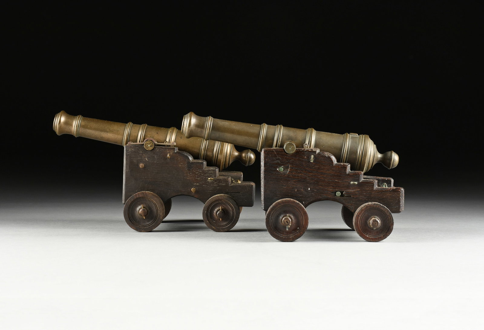 A PAIR OF GEORGE III CAST BRONZE SIGNAL CANNONS, FROM HMS ROYAL GEORGE, 1782,: A PAIR OF GEORGE III CAST BRONZE SIGNAL CANNONS, FROM HMS ROYAL GEORGE, 1782, each engraved, "Relic of the / ROYAL GEORGE / Sunk 1782 / raised 1840," on later step-carved oak carriages with end-cut oa