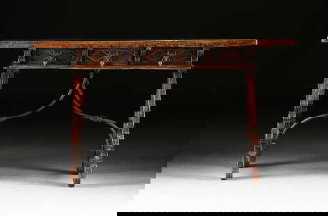 A SPANISH BAROQUE WALNUT AND WROUGHT IRON TRESTLE LIBRARY TABLE, 18TH CENTURY,: A SPANISH BAROQUE WALNUT AND WROUGHT IRON TRESTLE LIBRARY TABLE, 18TH CENTURY, the thick rectangular single plank top with curled grain, on a three-drawer frieze with rhombus lozenge carved faces and