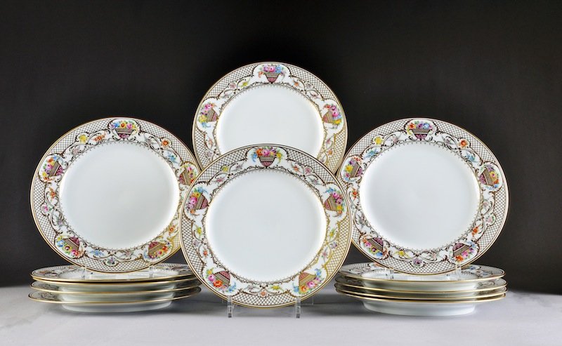 A SET OF TWELVE DRESDEN HELENA WOLFSOHN PARCEL GILT: A SET OF TWELVE DRESDEN HELENA WOLFSOHN PARCEL GILT AND POLYCHROME DECORATED DINNER PLATES, OVERGLAZE BLUE DECORATOR'S MARKS, RETAILED PALAIS ROYAL, HABANA, CUBA, EARLY 20TH CENTURY, each with a trell