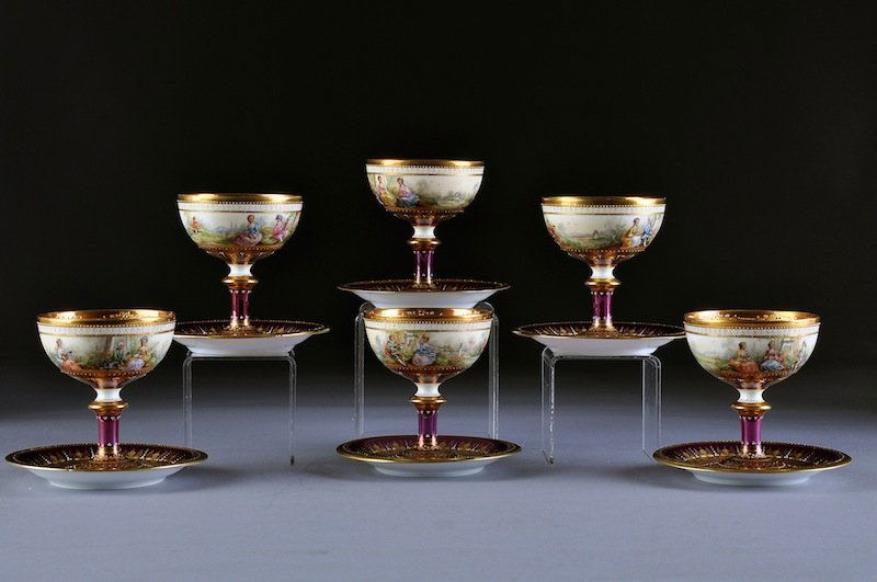 A SET OF SIX DRESDEN ELABORATELY PARCEL GILT AND P: A SET OF SIX DRESDEN ELABORATELY PARCEL GILT AND POLYCHROME PAINTED IRIDESCENT RASPBERRY GROUND STEMWARE AND SAUCERS, DECORATED BY THE AMBROSIUS LAMM COMPANY, EARLY 20TH CENTURY, each with an interior