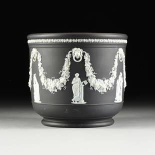 A WEDGWOOD BLACK AND WHITE JASPERWARE CACHEPOT, MUSES WITH GARLAND, ENGLISH, EARLY 20TH CENTURY: A WEDGWOOD BLACK AND WHITE JASPERWARE CACHEPOT, MUSES WITH GARLAND, ENGLISH, EARLY 20TH CENTURY, a black ground is overlaid with white bisque porcelain, the slightly rolled mouth is encircled by a flo