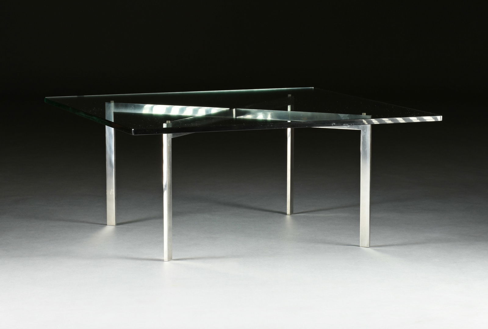 BARCELONA COFFEE TABLE, BY LUDWIG MIES VAN DER ROHE AND LILLY REICH, KNOLL PRODUCTS, 1950-1979: BARCELONA COFFEE TABLE, BY LUDWIG MIES VAN DER ROHE AND LILLY REICH, KNOLL PRODUCTS, 1950-1979, the 3/4" thick beveled glass square top on a stainless steel "X" form base, engraved with the monogram,