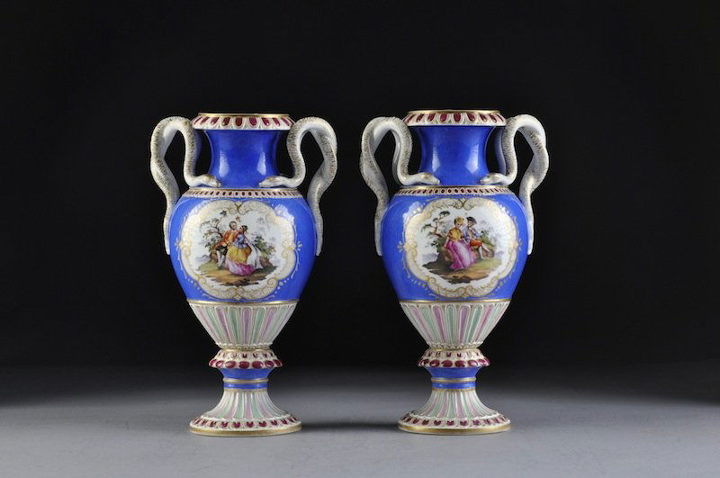 A PAIR OF MEISSEN BLUE-GROUND TWO-HANDLED VASES, D: A PAIR OF MEISSEN BLUE-GROUND TWO-HANDLED VASES, DOUBLE STRIKE UNDERGLAZE BLUE CROSSED SWORDS MARKS, each of ovoid form and centering polychrome decorated shaped reserves enclosing courting couples se