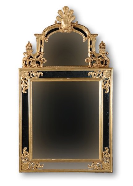 A GEORGE I STYLE PARCEL GILT AND CARVED WOOD MANTL: A GEORGE I STYLE PARCEL GILT AND CARVED WOOD MANTLE MIRROR, 20TH CENTURY, the arched cornice centering a stylized leaf pendant above a conforming mirrored plate flanked by scrolling and blossoming aca