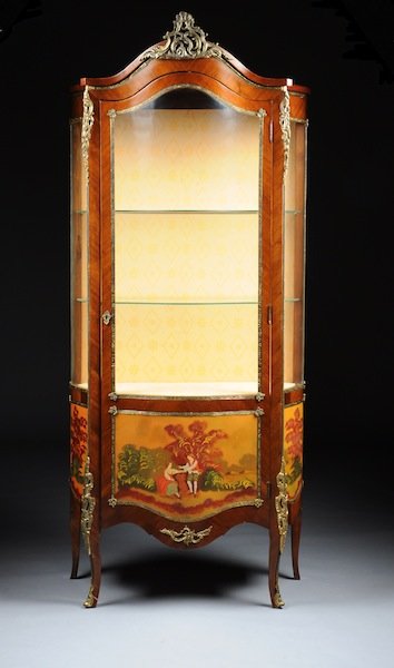 A LOUIS XV STYLE GILT METAL MOUNTED AND POLYCHROME: A LOUIS XV STYLE GILT METAL MOUNTED AND POLYCHROME PAINTED CARVED WOOD VITRINE, LATE 20TH CENTURY, the arched cornice centering a reticulated scrolling pendant above a bombe glazed door over a lower p