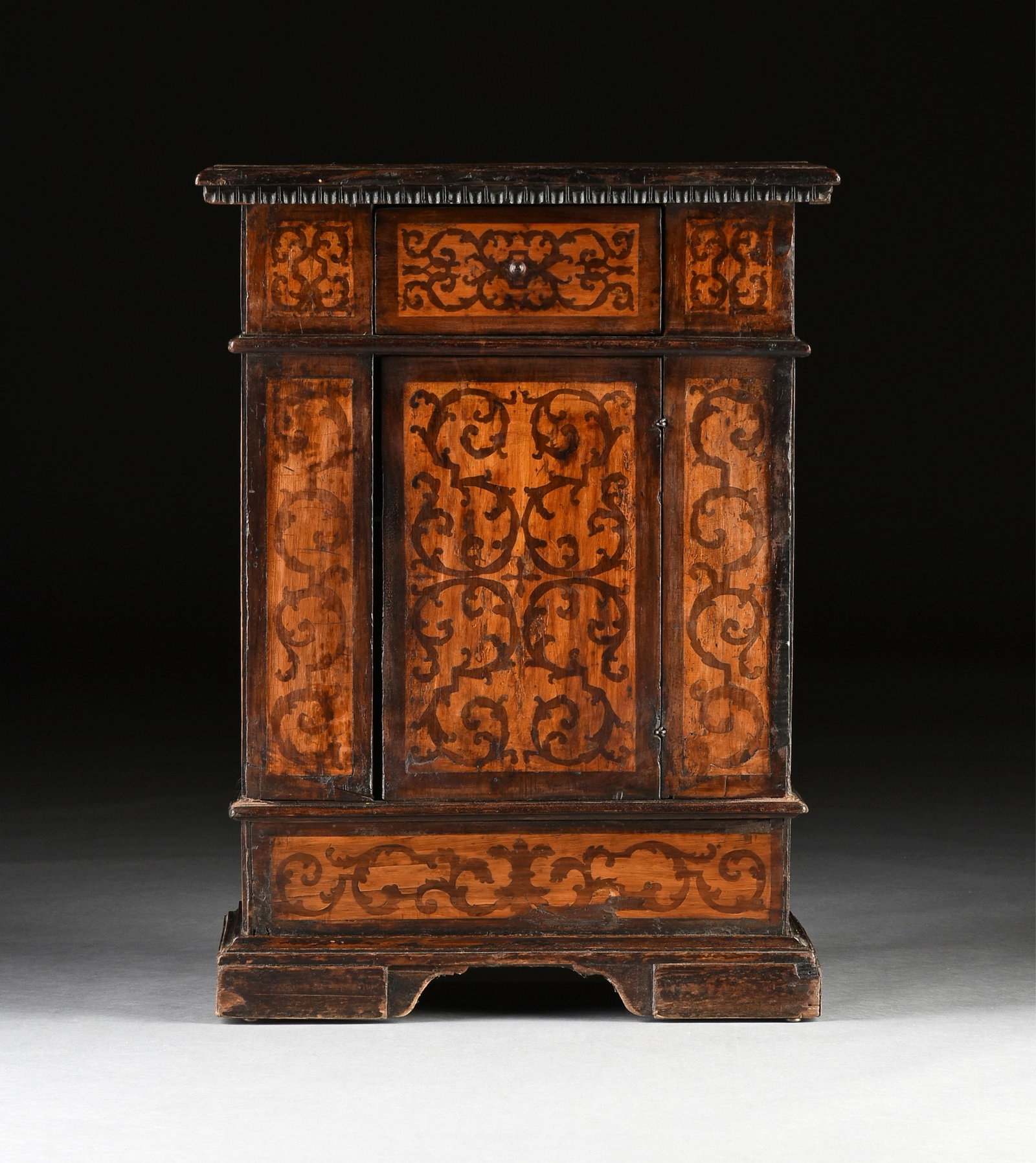 AN ITALIAN BAROQUE SEAWEED MARQUETRY INLAID OAK SINGLE CUPBOARD CABINET, 17TH CENTURY: AN ITALIAN BAROQUE SEAWEED MARQUETRY INLAID OAK SINGLE CUPBOARD CABINET, 17TH CENTURY, the rectangular top with repeating hammered grid and incised "folk" banding, over a dentil carved molding with wi